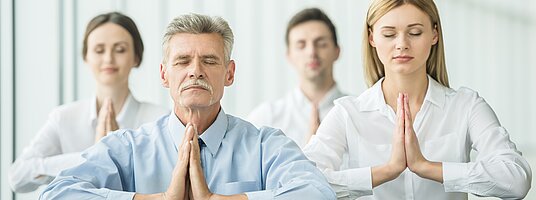 Geschäftsleute machen im Büro Übungen